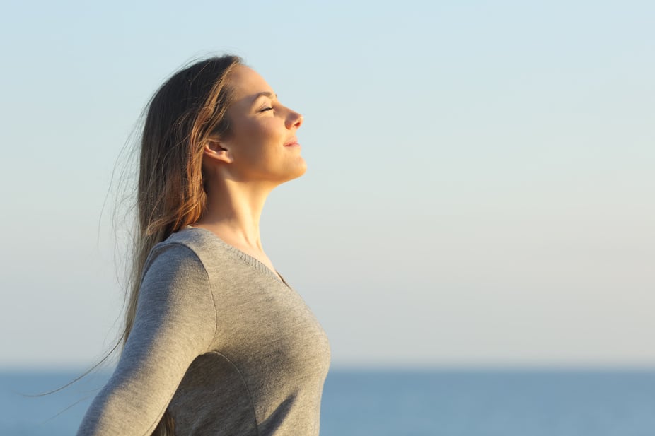 Woman breaths fresh air on the beach