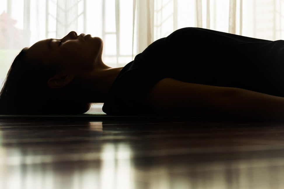 A woman laying on yoga mat relaxing. Meditation.